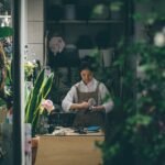 Small business owner standing beside a table in a shop, illustrating AI tools for small businesses