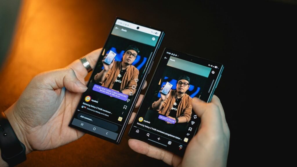 Hands holding two smartphones showing identical screens, illustrating transferring data from an old phone to a new phone