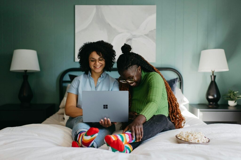 Woman using a laptop on a bed at home, illustrating a laptop buying guide for 2026